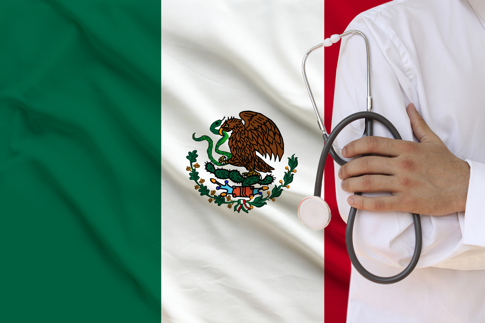 male doctor in white coat holding in his hand a medical instrument with a stethoscope against the background of the national flag, close-up, concept, copy space Como Ser Agente De Seguros GNP En Mexico